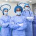 Group of medical surgeons wearing hospital scrubs in operating theatre ...